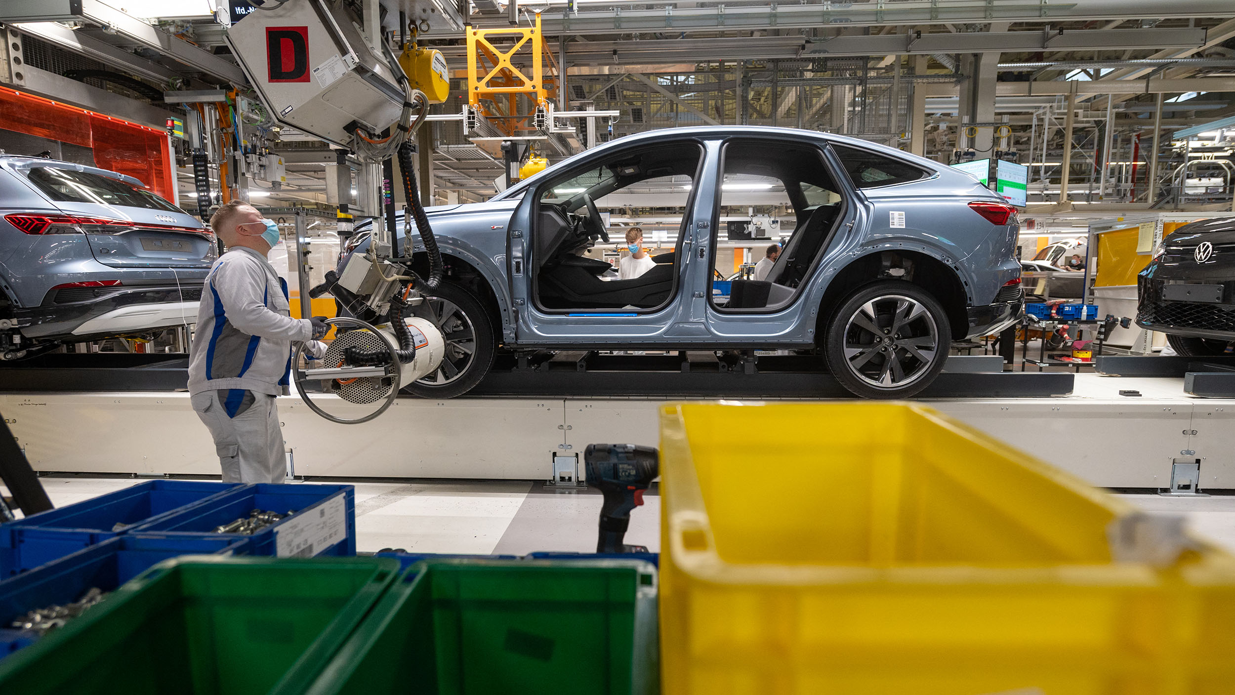 05 October 2021, Saxony, Zwickau: Employees assemble an Audi Q4 e-tron at the Volkswagen plant in Zwickau. A good six months after the launch of the SUV, Zwickau has become Audi's largest production site for electric vehicles. In addition to the VW plant in Zwickau, Audi also builds fully electric vehicles in Neckarsulm and Brussels. The first electric car planned for the Ingolstadt headquarters is the Q6, which is scheduled for market launch in 2023. Audi returned to its founding location with the production of the Q4 e-tron. Photo: Hendrik Schmidt, Europress/AFP)