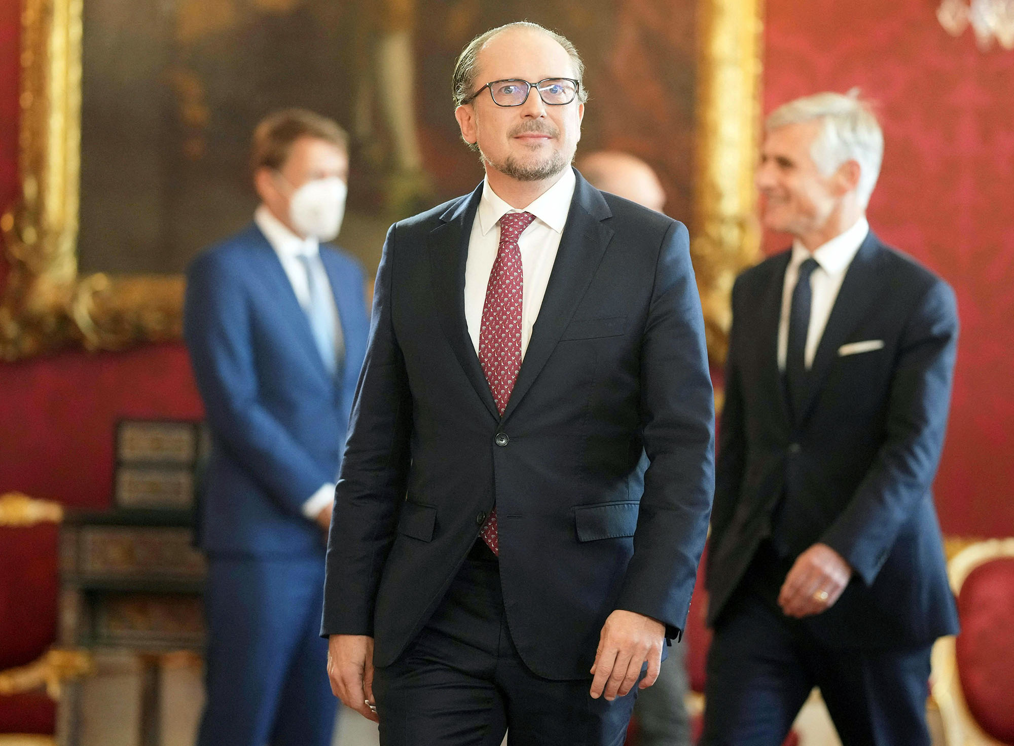Austria's outgoing Foreign Minister Alexander Schallenberg (C) arriveS for a swearing-in ceremony hosted by Austria's President at the Presidential Hofburg palace in Vienna, Austria, on October 10, 2021. – Alexander Schallenberg is to take over as Austrian chancellor after Sebastian Kurz on October 9, 2021 announced he was stepping down as chancellor following pressure on him to resign after he was implicated in a corruption scandal. (Photo by GEORG HOCHMUTH / APA / AFP) / Austria OUT