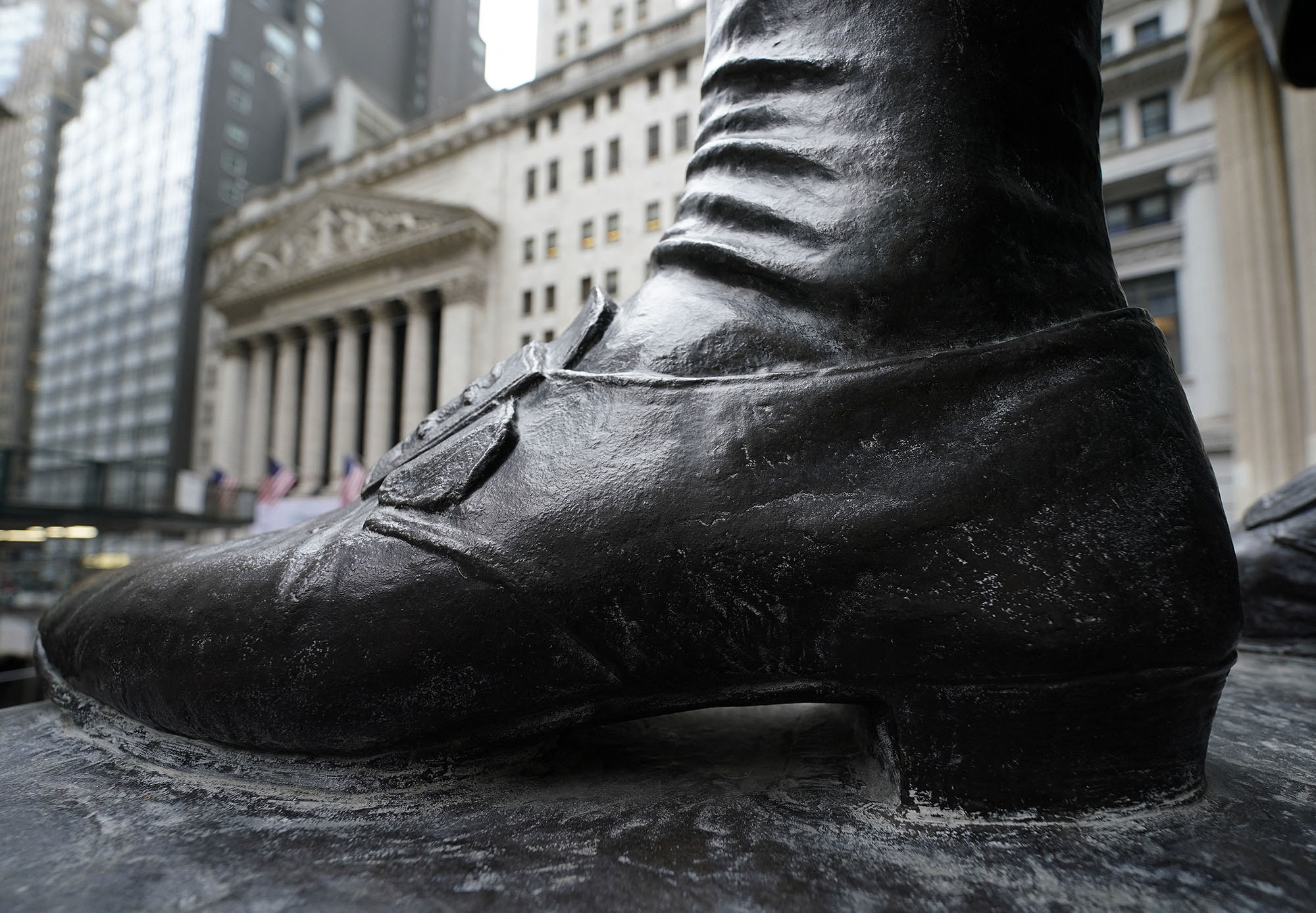 The shoe of the George Washington Statue at the Federal Hall National Memorial on Wall Street across the New York Stock Exchange on January 27, 2021. - Wall Street stocks slid to session lows Wednesday as Federal Reserve Chair Jerome Powell cautioned the US economic outlook was "highly uncertain" in light of the surging Covid-19 outbreak. (Photo by TIMOTHY A. CLARY / AFP)