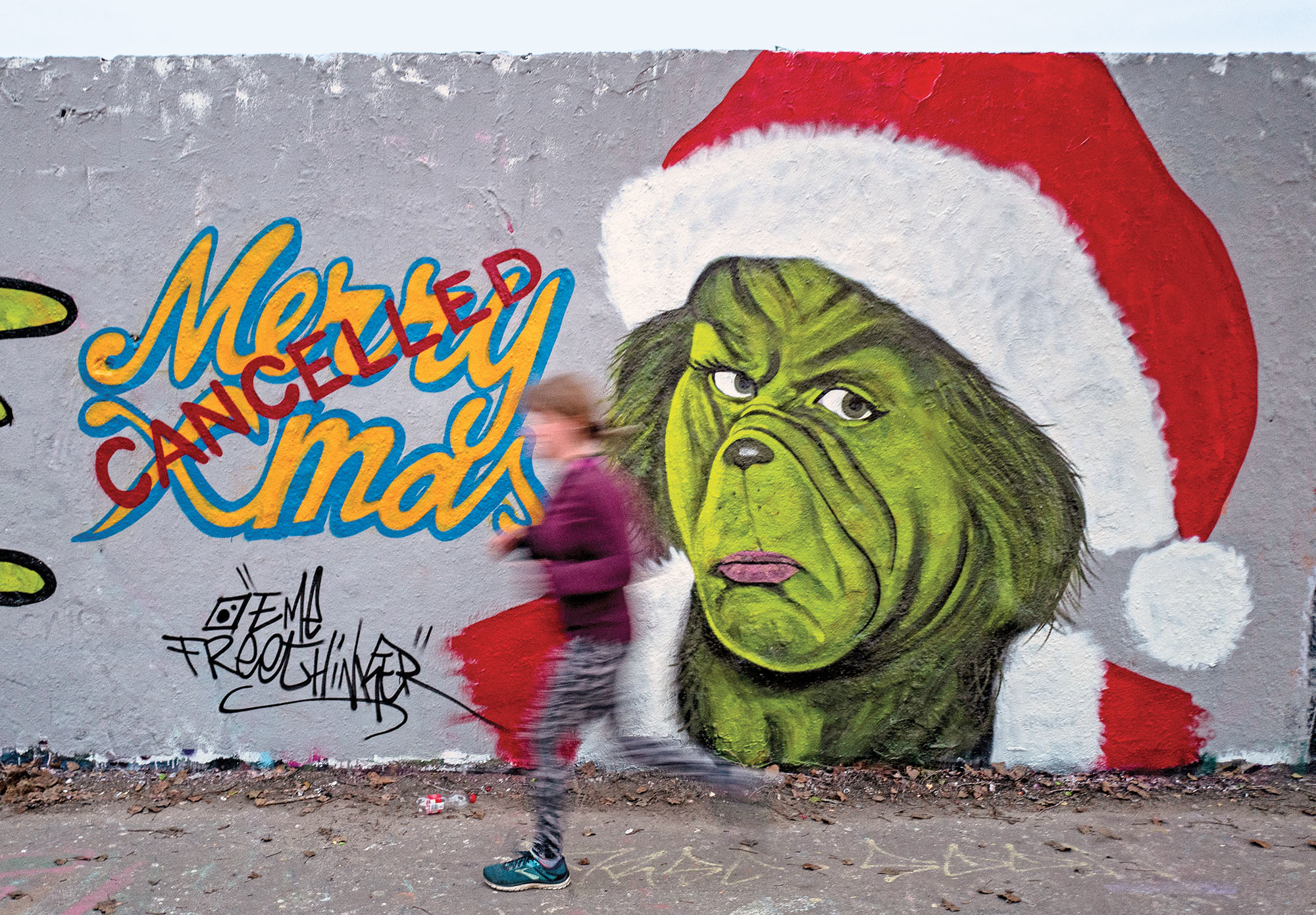 A mural painting by graffiti artist Eme Freethinker features a likeness of US author Dr Seuss' Grinch character with a "cancelled" stamp across a Merry Christmas sign, in Berlin on December 27, 2020. (Photo by John MACDOUGALL / AFP)